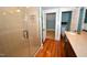 Bright bathroom featuring a glass-enclosed shower, tile surround, hardwood floors, and a vanity sink at 531 N Main St, Graham, NC 27253