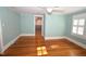 Inviting bedroom featuring hardwood floors, neutral walls, a window, and an adjacent walk-in closet at 531 N Main St, Graham, NC 27253