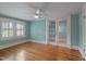 Bedroom with hardwood floors, light blue walls and adjacent sunroom at 531 N Main St, Graham, NC 27253
