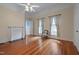 Bedroom with hardwood floors, fireplace, floral curtains, and access to the en-suite bathroom at 531 N Main St, Graham, NC 27253