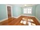 Well-lit bedroom with hardwood floors, a ceiling fan, and natural light from a large window at 531 N Main St, Graham, NC 27253