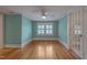 Bedroom with hardwood floors, light blue walls and adjacent sunroom at 531 N Main St, Graham, NC 27253