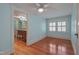Bright bedroom featuring hardwood flooring, a ceiling fan, and bathroom access at 531 N Main St, Graham, NC 27253