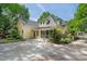 Beautiful yellow home featuring mature trees, landscaping, and a large driveway at 531 N Main St, Graham, NC 27253