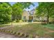 Inviting yellow home with mature trees, a spacious yard, and a charming front porch at 531 N Main St, Graham, NC 27253