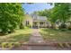 Inviting yellow home with mature trees, a spacious yard, and a charming front porch at 531 N Main St, Graham, NC 27253