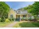 Charming yellow home featuring a welcoming front porch and well-maintained landscaping at 531 N Main St, Graham, NC 27253