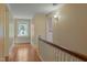Upstairs hallway with hardwood floors, stained glass window and access to bedrooms at 531 N Main St, Graham, NC 27253