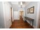 Well-lit hallway with hardwood floors, featuring a decorative table and access to multiple rooms at 531 N Main St, Graham, NC 27253