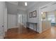 Hallway leading to kitchen with hardwood floors, gray console table, and white trim at 531 N Main St, Graham, NC 27253