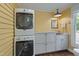 Laundry room with stacked washer/dryer and utility sink with storage at 531 N Main St, Graham, NC 27253