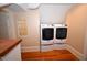 Bright laundry room featuring a modern, stacked washer and dryer set and a glass block window at 531 N Main St, Graham, NC 27253