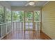 Charming screened-in porch with hardwood floors and views of the well-manicured front yard at 531 N Main St, Graham, NC 27253