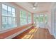 Light-filled sunroom with hardwood floors, beadboard walls, and multiple windows with backyard views at 531 N Main St, Graham, NC 27253