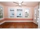 Bright sunroom featuring hardwood floors, pastel pink walls, and multiple large windows at 531 N Main St, Graham, NC 27253