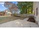 Well-maintained backyard with a combination of grass and concrete areas, mature trees, and a wooden fence at 5400 Cedarwood Dr, Raleigh, NC 27609