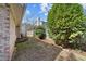 The side yard features a small mulched garden with a border and mature trees, and a wood fence at 5400 Cedarwood Dr, Raleigh, NC 27609