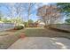 Large backyard with a small storage shed, mature trees, a wood fence, and grass at 5400 Cedarwood Dr, Raleigh, NC 27609