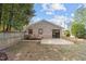 Brick home with a small patio area off the back, a wood fence, and a grassy yard at 5400 Cedarwood Dr, Raleigh, NC 27609