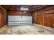 An unfinished garage, featuring an automatic garage door, storage, and a concrete floor at 5400 Cedarwood Dr, Raleigh, NC 27609