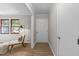 Hallway showcasing wood-look floors, neutral walls, and a stylish chair near a window at 5400 Cedarwood Dr, Raleigh, NC 27609