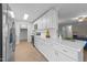 Well-lit kitchen features white cabinets, stainless steel appliances, and a view into the living room at 5400 Cedarwood Dr, Raleigh, NC 27609
