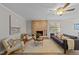 Inviting living room features a brick fireplace, ceiling fan, neutral walls and rug, and comfortable seating at 5400 Cedarwood Dr, Raleigh, NC 27609