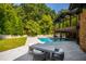 Picturesque backyard featuring a refreshing swimming pool, patio dining set, and lush green landscaping at 5601 Lambshire Dr, Raleigh, NC 27612