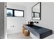 Modern bathroom with a stone sink, black hardware, and a large window offering natural light and views at 5601 Lambshire Dr, Raleigh, NC 27612