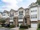 Beautiful townhomes showcasing stone accents, individual garages, and manicured landscaping at 5815 Cameo Glass Way, Raleigh, NC 27612