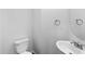 Half bathroom featuring a white toilet, sink, chrome faucet, and round mirror at 6013 Shelane Ct, Raleigh, NC 27610