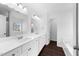 Bathroom with double sink vanity, white cabinets, granite countertop and dark wood floors at 6013 Shelane Ct, Raleigh, NC 27610