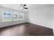 Spacious bedroom with three large windows, ceiling fan, and dark wood-look flooring at 6013 Shelane Ct, Raleigh, NC 27610