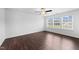 Bright bedroom with dark wood floors, ceiling fan, and natural light from three windows at 6013 Shelane Ct, Raleigh, NC 27610