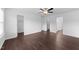 Spacious bedroom featuring dark wood floors, a ceiling fan, and multiple doorways at 6013 Shelane Ct, Raleigh, NC 27610