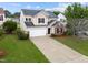 Attractive two-story home with a long driveway, attached garage, and mature landscaping at 6013 Shelane Ct, Raleigh, NC 27610