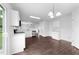 Open concept kitchen with white cabinetry, dark wood-look floors, and modern light fixture at 6013 Shelane Ct, Raleigh, NC 27610