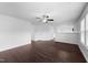 Open-concept living room with dark wood-look flooring, ceiling fan, and multiple entryways at 6013 Shelane Ct, Raleigh, NC 27610