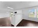 Open living area with dark wood-look floors, white walls, and an open view into the kitchen at 6013 Shelane Ct, Raleigh, NC 27610