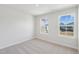 A simple bedroom with neutral carpet and two windows offering natural light and views of the community at 624 Brittany Ct, Durham, NC 27703
