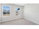 A clean, carpeted bedroom with two large windows offering community views and plenty of natural light at 624 Brittany Ct, Durham, NC 27703