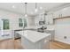 Bright, open kitchen featuring gray cabinets, stainless steel appliances, and a spacious white countertop island at 624 Brittany Ct, Durham, NC 27703