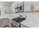 Close-up of the kitchen highlighting stainless steel stove and microwave, complemented by sleek gray cabinetry at 624 Brittany Ct, Durham, NC 27703