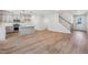 View of the open living area featuring wood-look floors, a modern kitchen, and a staircase to the upper level at 624 Brittany Ct, Durham, NC 27703