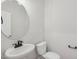 A well-lit powder room with a modern sink, faucet, and toilet at 624 Brittany Ct, Durham, NC 27703