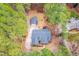 Aerial view of property featuring lush trees, lawn, long driveway, and detached garage at 6709 Windchase Dr, Rocky Mount, NC 27803