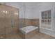 Bathroom with a glass enclosed shower and large soaking tub with window view at 6709 Windchase Dr, Rocky Mount, NC 27803
