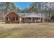 Traditional brick home featuring a covered front porch and lush front lawn at 6709 Windchase Dr, Rocky Mount, NC 27803