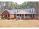 Classic brick home with inviting covered front porch and well-maintained landscaping at 6709 Windchase Dr, Rocky Mount, NC 27803