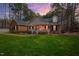 Charming brick home with welcoming front porch and manicured lawn, nestled among mature trees at 6709 Windchase Dr, Rocky Mount, NC 27803